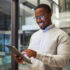 Business man using tablet in office building and smiling