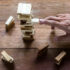 Hand making risky play by removing a block in Jenga game