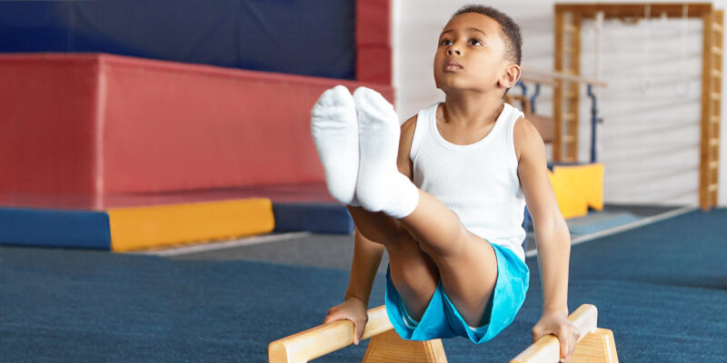 Self determined disciplined little sportsman doing balancing act