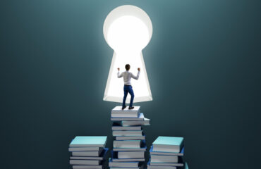 Education and knowledge concept with happy man reaching a keyhole by stepping on books