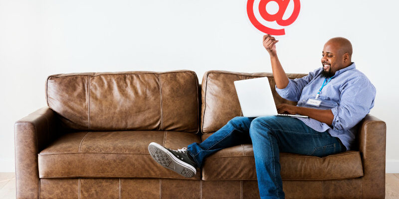 Man working on laptop whilst sitting on couch