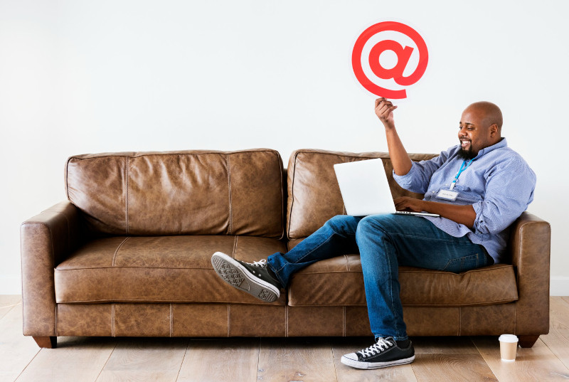 Man working on laptop whilst sitting on couch