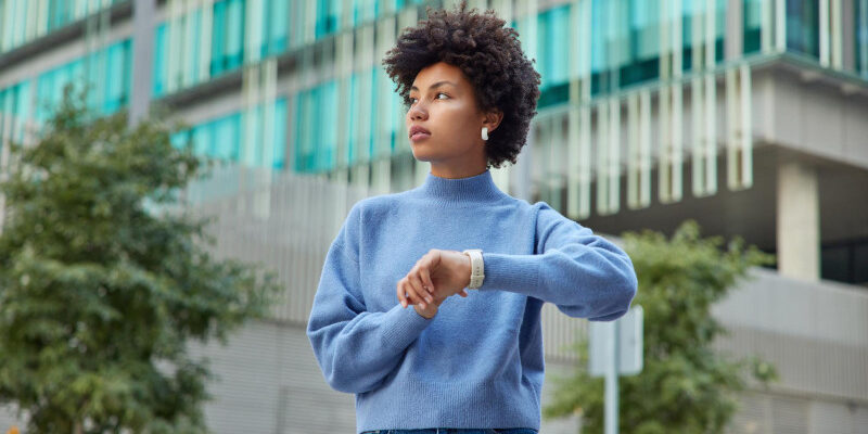 Young woman looking the other way from her wristwatch