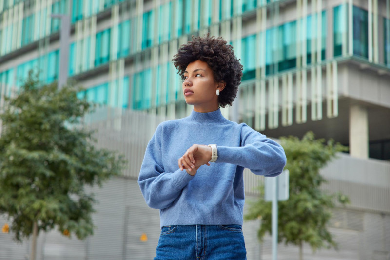 Young woman looking the other way from her wristwatch