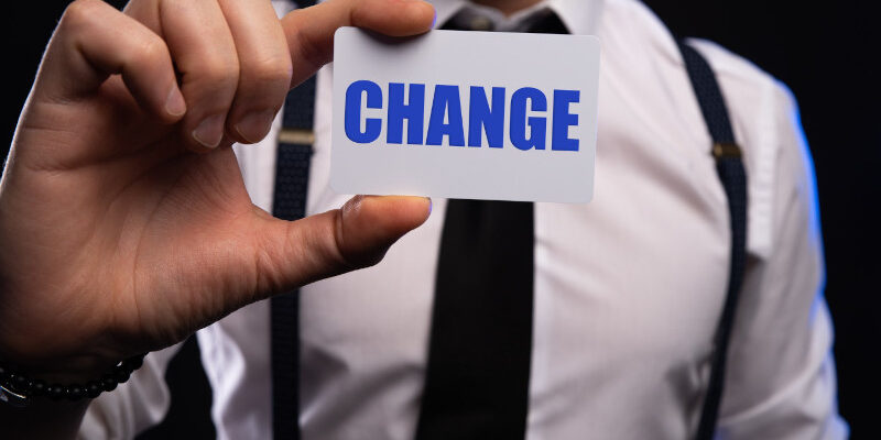 Businessman hand holding card with the word change