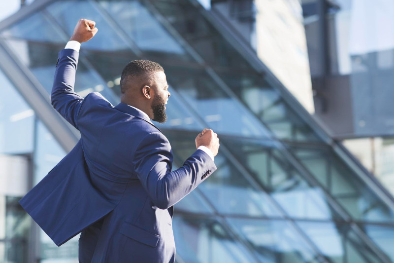 Man shaking fists rejoicing business success outdoors