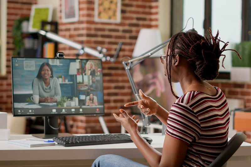 Employee attending video call business meeting on computer with webcam