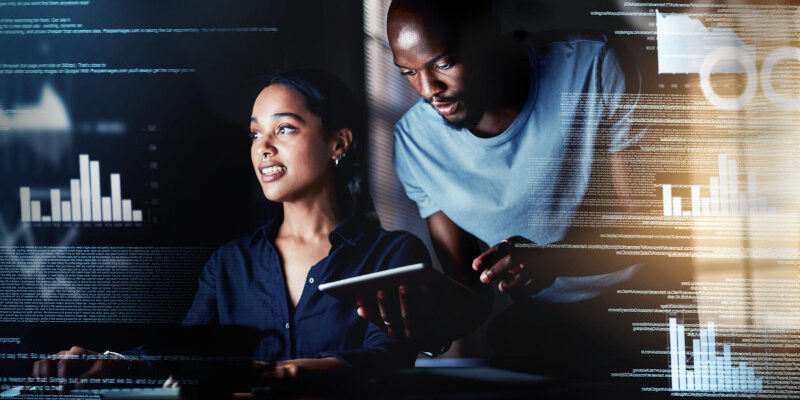 Woman working with code and man looking over her shoulder whilst holding a tablet all with code and chart overlays