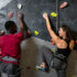 Friends climbing wall in indoor gym