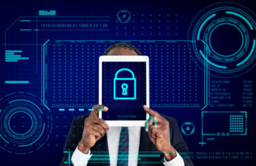 Man in suit holding tablet with Key lock password icon on it and tech security graphics in background