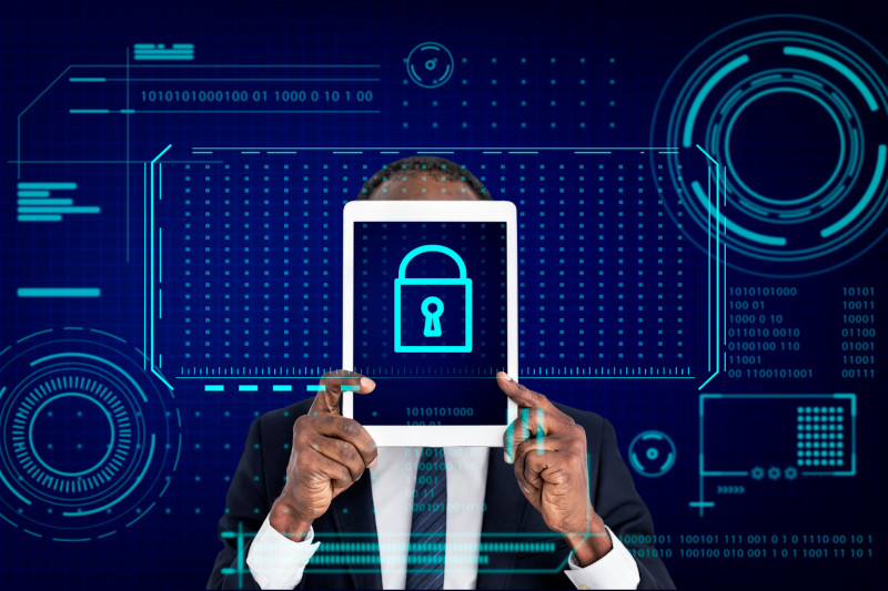 Man in suit holding tablet with Key lock password icon on it and tech security graphics in background