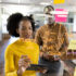 Man and woman in office brainstorming and writing on glass board