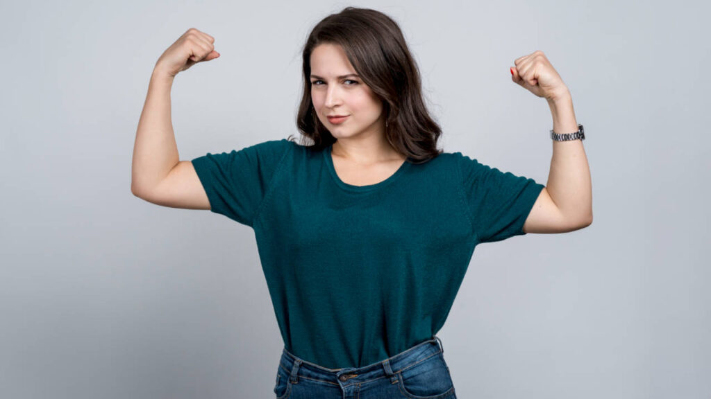 Woman flexing her arms with serious expression on her face