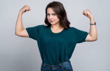 Woman flexing her arms with serious expression on her face