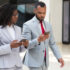 Business woman and business man conversing whilst walking and using mobile phones