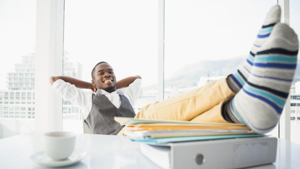 Relaxed businessman sitting in his chair with feet up