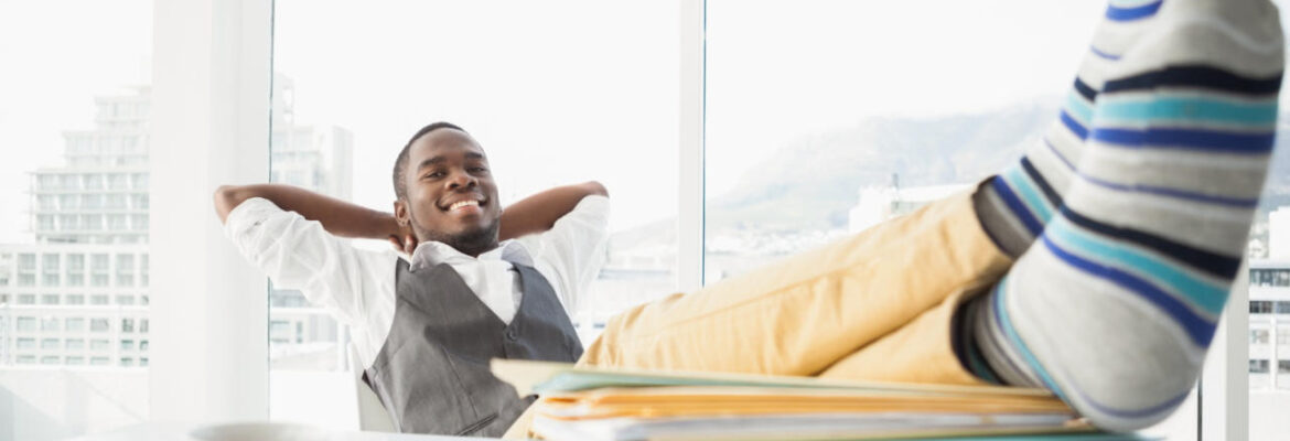 Relaxed businessman sitting in his chair with feet up