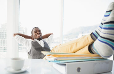 Relaxed businessman sitting in his chair with feet up