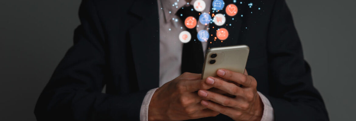 Concept of business man in a suit hlding a smartphone with a bubble of icons floating around it