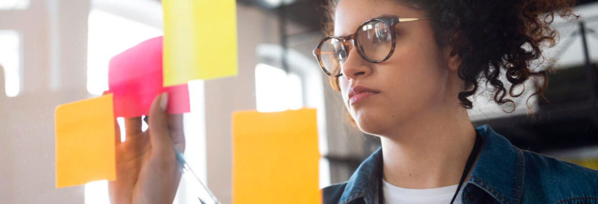 Young business woman with post its on a glass window