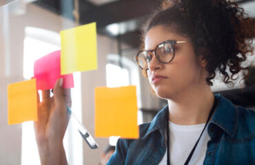 Young business woman with post its on a glass window