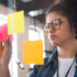Young business woman with post its on a glass window