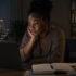 Young woman contemplating work in a city night